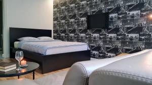 a bedroom with two beds and a tv on a wall at Teodor Apartment in Budraičiai