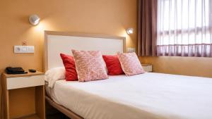 a bedroom with a large white bed with red pillows at Nuvi Mercado in Alicante +84 photos