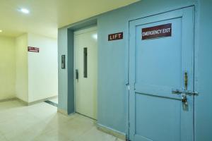 a hallway with two elevators and a emergency exit door at Itsy Hotels Aditya in Nagpur