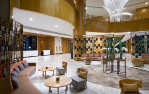 a hotel lobby with couches and tables and chairs at Meliá Yangon in Yangon