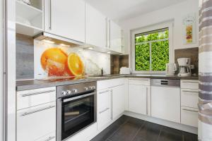 a kitchen with white cabinets and an oven with a window at Haus 50 in Röbel