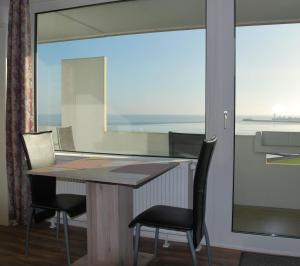 a table and chairs in a room with a large window at Haus Nautic Whg 809 Seesicht in Cuxhaven