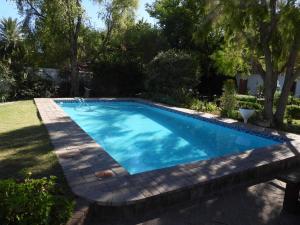 a swimming pool in a yard at Nguni Cottage in Graaff-Reinet
