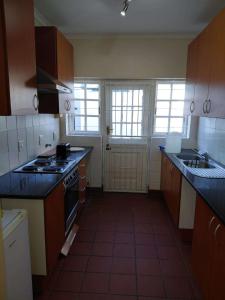 a kitchen with a sink and a stove top oven at Nguni Cottage in Graaff-Reinet