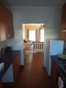 a kitchen with a refrigerator and a table and a couch at Nguni Cottage in Graaff-Reinet