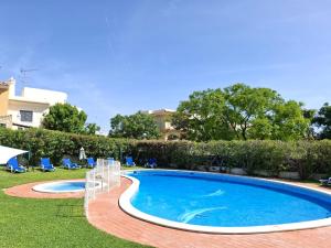 ein Swimmingpool in einem Garten mit Stühlen und einem Haus in der Unterkunft Hotel Monaco in Faro
