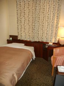 Un pat sau paturi într-o cameră la Hotel CROWN HILLS MIYOSHI