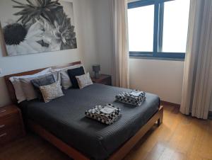 a bedroom with a bed with two boxes on it at Loreto Luxury in Arco da Calheta +11 photos