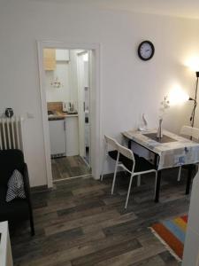 a living room with a table and chairs and a kitchen at FEWO Kutsch Watt Nr.3 in Cuxhaven