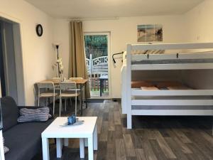 a living room with two bunk beds and a table at FEWO Kutsch Watt Nr.3 in Cuxhaven