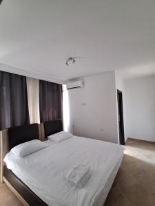 a bedroom with a large white bed with white sheets at Berane Rooms in Berane
