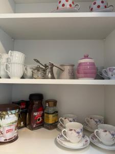 a shelf filled with dishes and cups and bowls at Apartment Harmony Sarajevo Vogošća in Vogošća