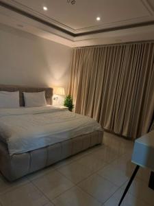 a bedroom with a bed and a window with curtains at شقق اجنحة تارا in Khamis Mushayt