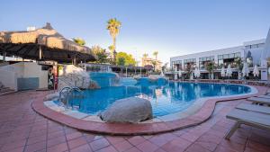 a swimming pool in a resort with rocks in it at Begonville Hotel in Marmaris