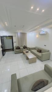 a large living room with couches and a screen at شقق اجنحة تارا in Khamis Mushayt