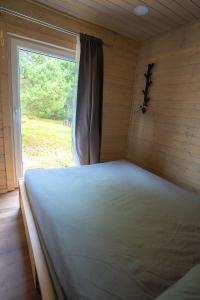 a large bed in a room with a window at Mērsraga namiņš in Mērsrags