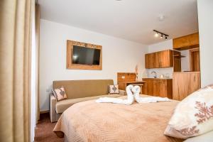 a bedroom with a bed with a towel animal on it at Cichowiański Folk & Prestige in Poronin