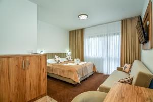 a hotel room with a bed and a couch at Cichowiański Folk & Prestige in Poronin