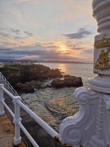 a view of the ocean at sunset from a lighthouse at "1930 Diecinueve Treinta" Apartamento Historico en Pleno Centro de Gijon in Gijón