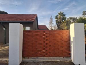 a red brick fence in front of a house at Trendy Tranquility in Secunda