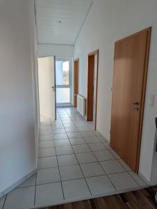 an empty hallway with a door and a tile floor at IBB Ferien- Monteurwohnung 3 Schlafzimmer 3 Betten in Ibbenbüren