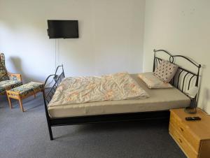 a bed in a room with a tv and a chair at IBB Ferien- Monteurwohnung 3 Schlafzimmer 3 Betten in Ibbenbüren