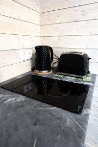 a black counter with a toaster and a telephone on it at Mērsraga namiņš in Mērsrags