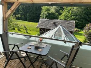 a table and chairs on a balcony with a view at Ferienwohnung Lippert in Pullenreuth
