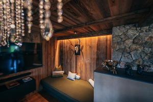 a room with a bed in a room with a stone wall at Alpin Chic by Alpe Chalets in Unterseefeld