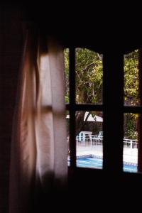a window with a view of a pool and a table at Cabañas Nazareth in Villa Carlos Paz