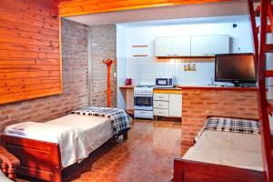 a small kitchen with two beds in a room at Cabañas Nazareth in Villa Carlos Paz