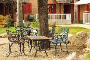 a table and chairs next to a tree at Cabañas Nazareth in Villa Carlos Paz