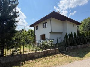 a small white house with a black fence at The Old Walnut House in Terziysko