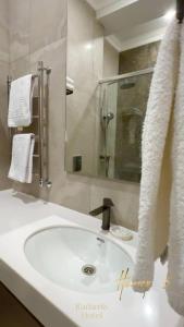 a bathroom with a white sink and a mirror at Radamis in Almaty