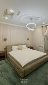 a bedroom with a large white bed with a chandelier at Radamis in Almaty +4 photos