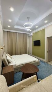 a bedroom with a bed and a table and a couch at Radamis in Almaty