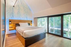 ein Schlafzimmer mit einem Bett und einem großen Fenster in der Unterkunft VERSOVERDE HOTEL Alzaia Naviglio Grande in Mailand + 76 Fotos