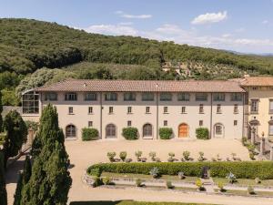 an exterior view of a large white building with a garden at Torre a Cona Wine Estate in Florence