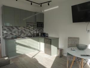 a kitchen with glass cabinets and a table in it at Sunset Dunes in Cape Town