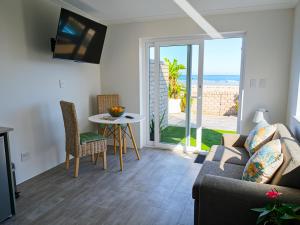 a living room with a couch and a table at Sunset Dunes in Cape Town