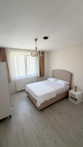 a bedroom with a large white bed and a chandelier at Galfa House in Bostancı