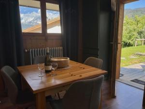 a table with a bottle of wine and two glasses at Spacious flat facing Mont Blanc in Combloux