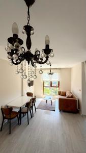 a living room with a chandelier and a table and chairs at Galfa House in Bostancı