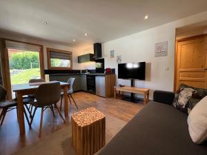 a living room with a couch and a table and a kitchen at Spacious flat facing Mont Blanc in Combloux