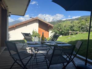 a table with chairs and an umbrella on a patio at Spacious flat facing Mont Blanc in Combloux