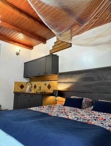 a bedroom with a blue bed and a kitchen at Kompleks Detlafówka in Dębki