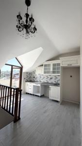 a kitchen with white cabinets and a chandelier at Galfa House in Bostancı +15 photos