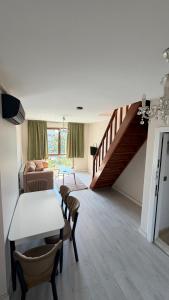 a living room with a table and chairs and a staircase at Galfa House in Bostancı