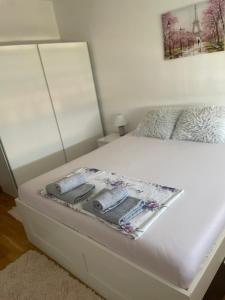a bed with white sheets and a blanket on it at Sophia in Vranje