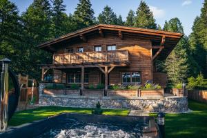 a log house with a pool in front of it at Alpin Chic by Alpe Chalets in Unterseefeld